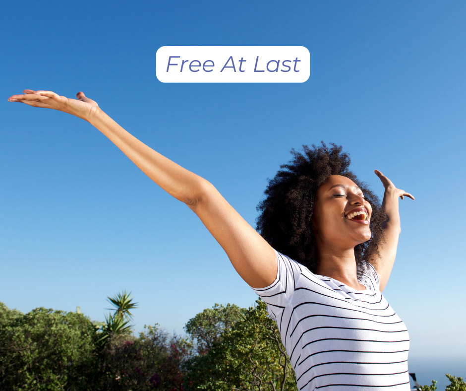 A woman with her arms outstretched, joyful because she is free at last.