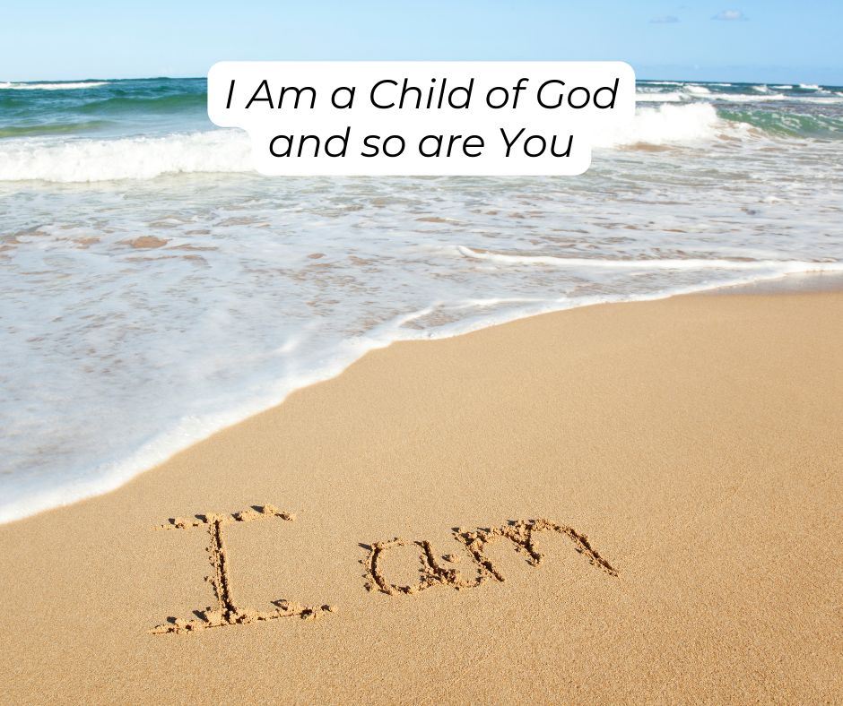 "I am" is written in the sand at the beach. I am a child of God and so are you.