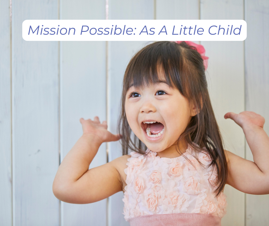 A young child with a big grin, enthusiastically raising her arms