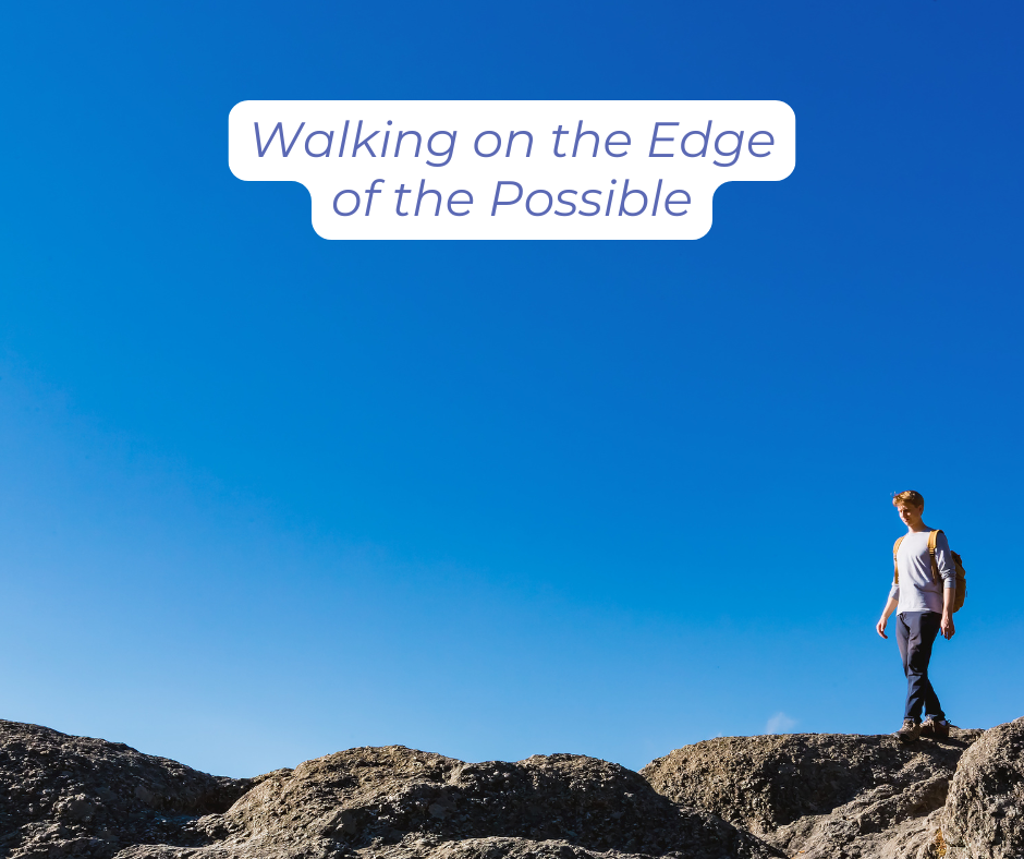 A person is walking along an edge of rocks
