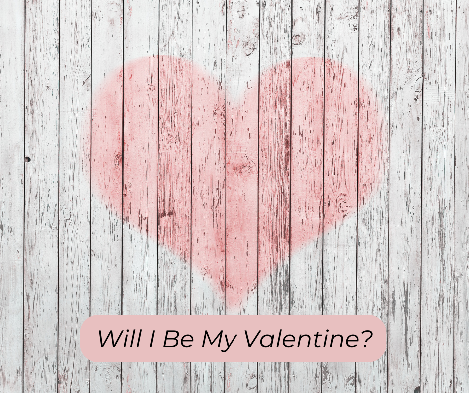 Pink heart on a wooden background. Text: Will I Be My Valentine?